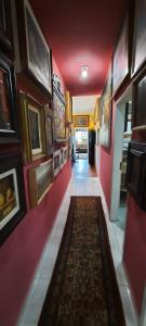 a hallway with red walls and a rug on the floor at Mini Hostel Fine Art in Vitória da Conquista