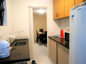 a kitchen with a sink and a kitchen with a table at Excelente Apto Próx. Centro Curitiba in Curitiba