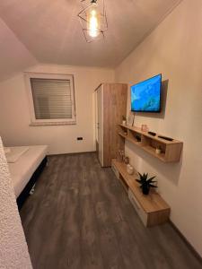 Gornji VakufDM Rooms lll的一间卧室，墙上有一张床和一台电视