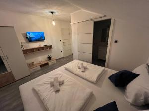 Gornji VakufDM Rooms lll的卧室配有2条白色毛巾。