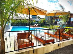 a swimming pool with chairs and umbrellas next to at Cabañas Posta Litoral in Colón