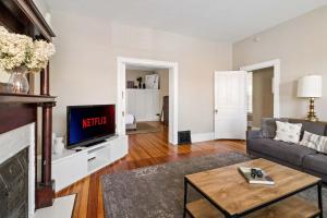 a living room with a couch and a tv at Pet-Friendly Benton Park 1BR Apt with Private Backyard in Soulard