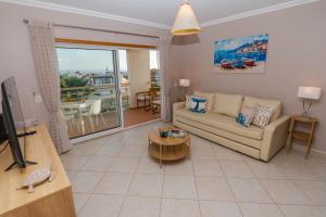 a living room with a couch and a table at Ver o Mar in Albufeira