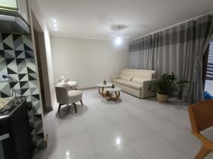 a living room with a couch and a table at Chácara Aricanga in Aracruz +4 photos