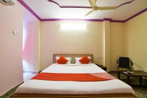 a bedroom with a large bed with red pillows at Hotel O Radika Residency in Warangal +36 photos