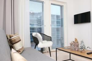 a living room with a couch and a table and a window at Arctic Aurora Suite Rovaniemi in Rovaniemi