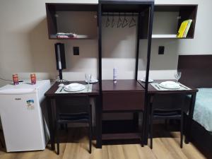 una habitación con un escritorio con dos sillas y una cama en Smart Malls Mundurucus 1427 batista campos, en Belém