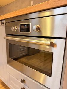 Un horno de plata con un reloj encima. en Crown Apartment Park View, en Ukmergė 10 fotos más