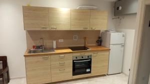 Una cocina con gabinetes de madera y un refrigerador blanco. en Bait de la nef, en Isolaccia