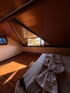Zimmer im Dachgeschoss mit einem Bett und einem Fenster in der Unterkunft Pousada Rio Cipó in Serra do Cipo