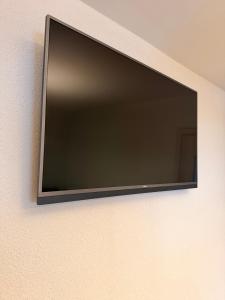 a flat screen tv hanging on a wall at Crown Apartment Park View in Ukmergė +10 photos
