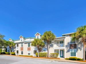 un edificio con palme di fronte a una strada di The Village 622 a Blue Gulf Beach
