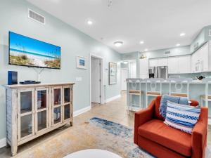 un soggiorno con un divano e una TV a parete di The Village 622 a Blue Gulf Beach