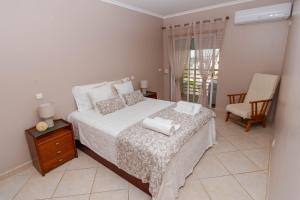 a bedroom with a bed with two towels on it at Ver o Mar in Albufeira +45 photos