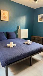 - une chambre bleue avec un lit et 2 serviettes dans l'établissement Cosy 5 - Montbéliard, à Montbéliard