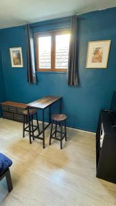une chambre bleue avec une table et deux tabourets dans l'établissement Cosy 5 - Montbéliard, à Montbéliard
