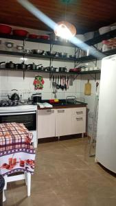 a kitchen with a stove and some pots and pans at Cantinho das Palmeiras em Itapoá- Casa c piscina p 6 pessoas in Itapoa