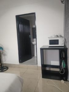 eine Mikrowelle auf einem Tisch in einem Zimmer in der Unterkunft Dups Guest House, in Pietermaritzburg