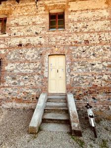 a brick building with a door and stairs in front at La Locanda della Mandria 1 in Venaria Reale