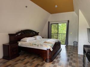 a bedroom with a wooden bed and a balcony at Eco Hotel Villas del Tortuguero in Cariari