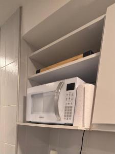 eine Mikrowelle auf einem Regal in einer Küche in der Unterkunft Appartement à 200 de la mer in Caucaia