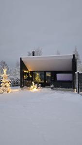 a large building with snow on the ground at Arctic Circle Aurora Guesthouse in Rovaniemi