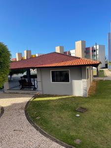 ein kleines Haus mit rotem Dach auf einem Rasen in der Unterkunft Appartement à 200 de la mer in Caucaia