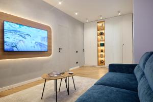 a living room with a blue couch and a table at CHANTTAL Luxury - ACADEMY in Bucharest