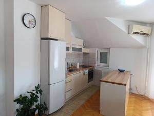 una cucina con elettrodomestici bianchi e un orologio sul muro di Stan na dan Brčko a Brčko