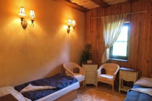 a bedroom with a bed and two chairs and a window at Three Chalets Vrútky in Vrútky +35 photos