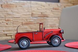 a red toy car sitting on top of a table at Gyula Vár Prémium Apartman in Gyula