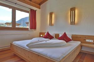 アルツル・イム・ピッツタールにあるKinderbauernhof Lenelerのベッドルーム1室(大型ベッド1台、赤い枕付)