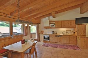 アルツル・イム・ピッツタールにあるKinderbauernhof Lenelerの木製のテーブルとダイニングルームのあるキッチン