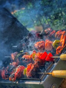 a grill with meat and peppers cooking on at Rafters Retreat Coorg The Riverside Homestay in Srimangala