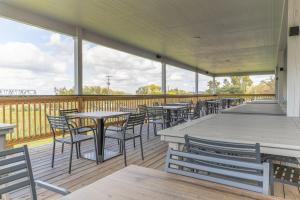 una fila di tavoli e sedie su un ponte di The Bridges Hotel a Natchez