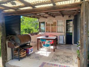 a patio with a table and a wooden pergola at Nuestro Lugar in Río Ceballos