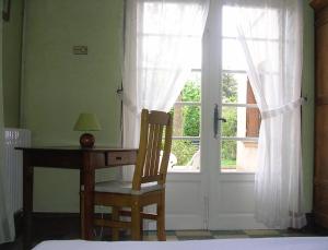 a bedroom with a desk and a window and a chair at Le Jardin in Gréoux-les-Bains