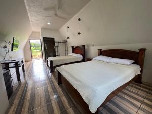 a bedroom with two beds and a desk in it at Eco Hotel Villas del Tortuguero in Cariari
