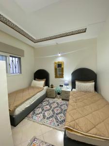 Un dormitorio con dos camas y una alfombra. en Dar El Yacout, en Rabat
