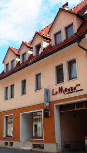 a building with a sign on the side of it at Penzion Le Monde in Bardejov