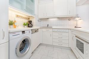 eine weiße Küche mit Waschmaschine und Trockner in der Unterkunft Strandhotel Dahme Schwalbennest Dahme in Dahme