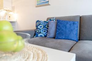 ein Wohnzimmer mit einem Sofa und blauen Kissen in der Unterkunft Strandhotel Dahme Schwalbennest Dahme in Dahme