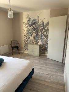 a bedroom with a bed and a painting on the wall at Villa by Nesma in Châtellerault