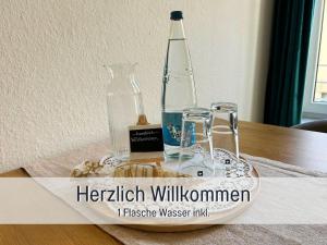 a glass bottle and two glasses on a table at StayWest52 - Balkon, WLAN, Parkplatz in Ulm +26 photos