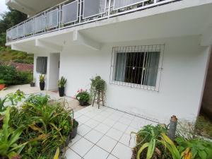 a white house with a balcony and plants at AP do Vale em Blumenau in Blumenau