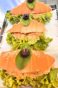 une rangée de sandwichs avec de la laitue et des olives dessus dans l'établissement Pousada Mar de vênus, à Fernando de Noronha 48 autres photos