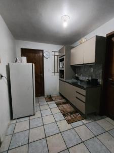 a kitchen with a refrigerator and a tiled floor at AP do Vale em Blumenau in Blumenau