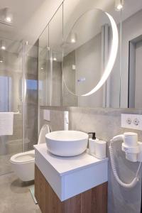 a bathroom with a sink and a toilet and a mirror at CHANTTAL Luxury - ACADEMY in Bucharest