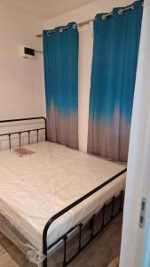 克拉约瓦Km 0 , ultracentral的带蓝色窗帘的房间里的一张床