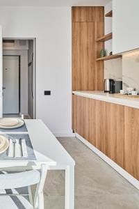 a kitchen with a white table and wooden cabinets at CHANTTAL Luxury - ACADEMY in Bucharest +20 photos